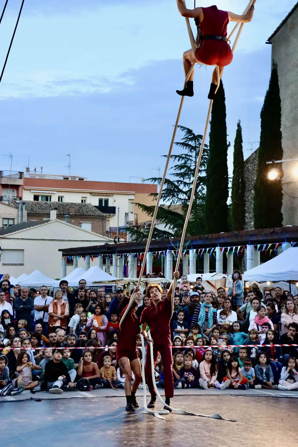 Acròbata aèria penjada davant el campanar de Torrelles